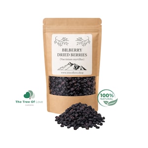 Könnte beinhalten: Ein brauner Papierbeutel mit dunkelvioletten getrockneten Heidelbeeren. Das Etikett zeigt BILBERRY DRIED BERRIES (Vaccinium myrtillus), eine Berggrafik und die Website www.treeoflove.shop. Ein Haufen loser getrockneter Beeren liegt davor.
