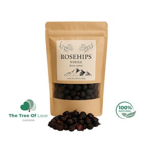 Könnte beinhalten: Ein brauner Standbodenbeutel aus Kraftpapier mit ganzen getrockneten Hagebutten. Das Etikett trägt die Aufschrift ROSEHIPS WHOLE (Rosa canina) mit einer Berggrafik und Website. Ein Haufen dunkler, runzliger Hagebutten liegt vor dem Beutel.