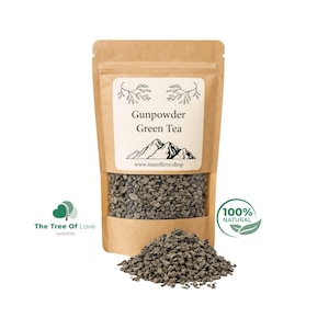 May include: A brown kraft paper pouch containing Gunpowder Green Tea, with a clear window displaying the dark, rolled tea leaves. The label features a mountain illustration and the text Gunpowder Green Tea and www.treeoflove.shop.