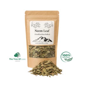 May include: A brown kraft paper pouch containing dried green neem leaves. The label features the text Neem Leaf (Azadirachtae Indica), a mountain graphic, and the website www.treeoflove.shop. A pile of loose dried neem leaves sits in front.
