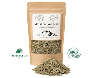 Puede incluir: Una bolsa de papel kraft marrón que contiene hojas de malvavisco secas (Althaea officinalis). La etiqueta presenta un gráfico de montaña y el texto www.treeoflove.shop. Un montón de hojas verdes picadas se encuentra frente a la bolsa.