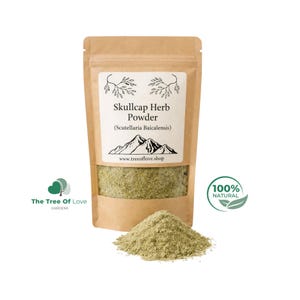 Peut inclure: Un sachet en papier kraft brun contenant de la poudre d'herbe de scutellaire (Scutellaria Baicalensis) avec une étiquette blanche ornée de montagnes et le texte www.treeoflove.shop. Un tas de poudre herbacée vert clair est devant le sachet.