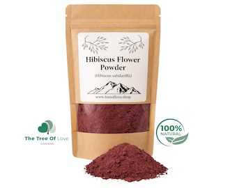 May include: A brown kraft paper pouch containing deep red hibiscus flower powder. The white label features the text Hibiscus Flower Powder (Hibiscus sabdariffa), a mountain graphic, and the website www.treeoflove.shop, with a pile of powder in front.