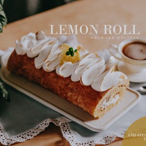 May include: A lemon roll cake topped with meringue frosting and a lemon slice. The cake is on a white plate and a blue tablecloth. The text "LEMON ROLL ORCHARD RECIPES" is at the top of the image. The text "PDF RECIPE AND STEP BY STEP TUTORIAL" is at the bottom of the image.