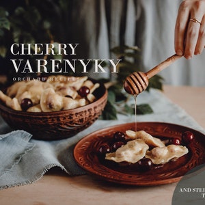 May include: A close-up of a plate of cherry varenyky, a type of Ukrainian dumpling, topped with honey. The varenyky are in a rustic brown bowl with a carved design. The text "CHERRY VARENYKY ORCHARD RECIPES" is at the top of the image. The text "PDF RECIPE AND STEP BY STEP TUTORIAL" is at the bottom of the image.