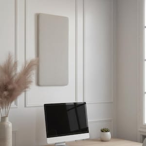 May include: A modern home office setup featuring a light wood desk with a computer, keyboard, and mouse. A beige sound-dampening panel hangs on the white wall. A vase of pampas grass adds a touch of decor.