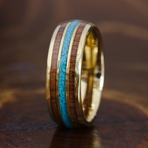May include: A gold band with a turquoise and wood inlay. The band is made of metal and has a polished finish.