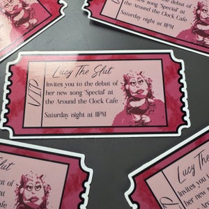 May include: Pink and white VIP ticket-shaped stickers. The stickers feature the text "Lucy The Slut" and "Invites you to the debut of her new song 'Special' at the Around the Clock Cafe Saturday night at IIPM". A cartoon image of a woman is also on the sticker.