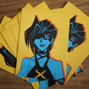 Pode incluir: Um conjunto de cart&otilde;es amarelos de impress&atilde;o sob demanda com uma ilustra&ccedil;&atilde;o azul e preta de uma mulher com um &uacute;nico olho. A mulher tem cabelo preto e est&aacute; vestindo um top preto com um design em X amarelo.
