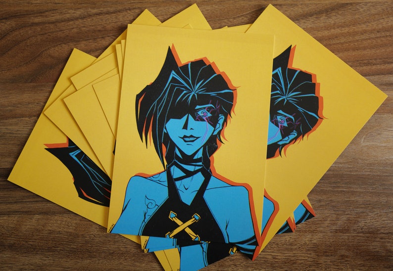 Pode incluir: Um conjunto de cart&otilde;es amarelos de impress&atilde;o sob demanda com uma ilustra&ccedil;&atilde;o azul e preta de uma mulher com um &uacute;nico olho. A mulher tem cabelo preto e est&aacute; vestindo um top preto com um design em X amarelo.