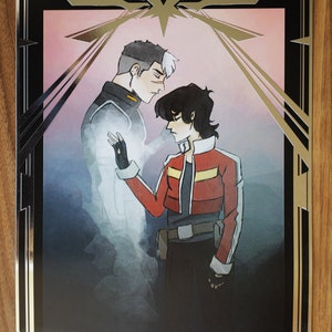 Peut inclure: Une impression encadr&eacute;e en noir et or repr&eacute;sentant une illustration stylis&eacute;e de deux personnages. Le personnage de gauche est une figure translucide avec un sch&eacute;ma de couleurs blanc et gris. Le personnage de droite est une figure plus solide avec un sch&eacute;ma de couleurs rouge et noir. L'arri&egrave;re-plan est un rose doux avec un d&eacute;grad&eacute; gris clair.