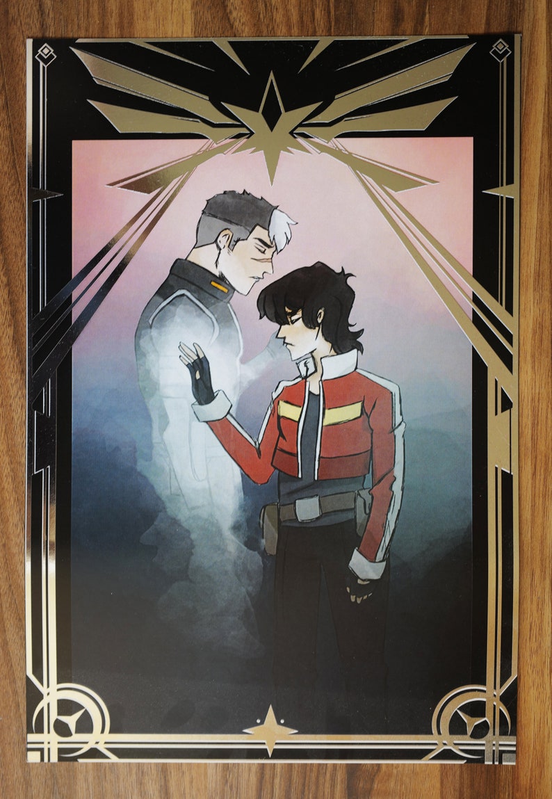 Peut inclure: Une impression encadr&eacute;e en noir et or repr&eacute;sentant une illustration stylis&eacute;e de deux personnages. Le personnage de gauche est une figure translucide avec un sch&eacute;ma de couleurs blanc et gris. Le personnage de droite est une figure plus solide avec un sch&eacute;ma de couleurs rouge et noir. L'arri&egrave;re-plan est un rose doux avec un d&eacute;grad&eacute; gris clair.