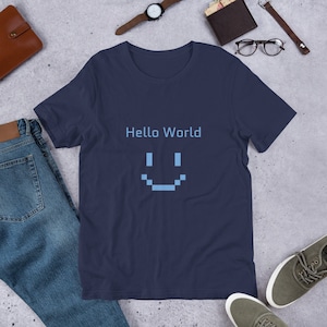 May include: A navy blue t-shirt featuring the text "Hello World" and a pixelated smiley face.