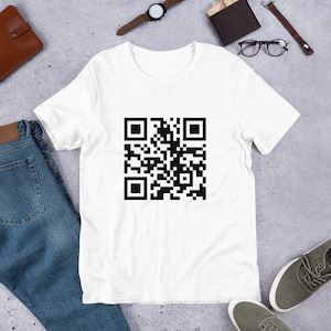 Puede incluir: Camiseta blanca con un código QR negro impreso en la parte delantera.