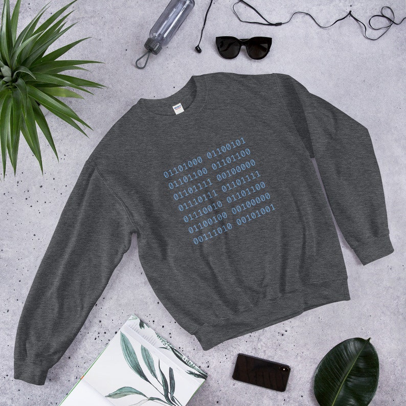 May include: A dark gray sweatshirt with a blue design of binary code on the front. The code reads: 01101000 01100101 01101100 01100100 01101111 00100000 01110111 01101111 01110010 01101100 01100100 00100000 00111010 00101001.
