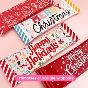 May include: Several Christmas-themed chocolate wrappers with festive designs. The wrappers feature text like "Merry Christmas" and "Happy Holidays", along with holiday graphics such as snowmen, reindeer, and snowflakes. The wrappers are red, white, and blue.