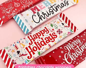 May include: Several Christmas-themed chocolate wrappers with festive designs. The wrappers feature text like "Merry Christmas" and "Happy Holidays", along with holiday graphics such as snowmen, reindeer, and snowflakes. The wrappers are red, white, and blue.