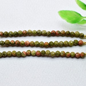 Puede incluir: Tres hebras de cuentas de piedras preciosas verdes y rosadas con tapas doradas. Cada hebra tiene aproximadamente 20 cuentas.