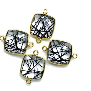May include: Four gold-toned square-shaped pendants with clear quartz stones containing black inclusions. Each pendant has two gold-toned loops for attaching to a chain or cord.
