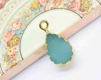 May include: A gold-plated pendant with a light blue teardrop-shaped stone.