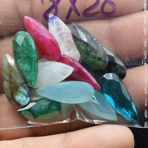 Peut inclure: Un sac en plastique rempli de cabochons de pierres précieuses de différentes couleurs, notamment vert, bleu, rouge et blanc. Le sac est étiqueté "8X20".