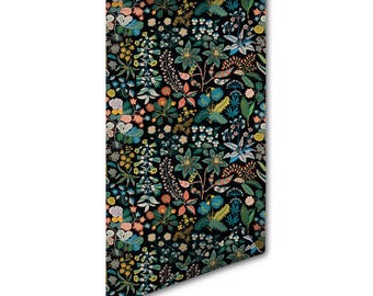 Op de afbeelding: Een rechthoekige rol behang met een dicht botanisch patroon op een zwarte achtergrond. Het ontwerp bevat diverse gestileerde bloemen en bladeren in tinten van blauwgroen, oranje, geel, roze en wit, gerangschikt in een herhalend bloemmotief.