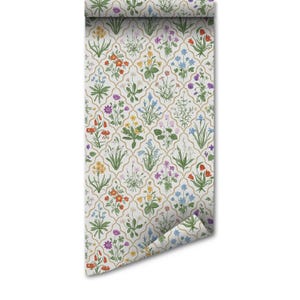 May include: A roll of wallpaper with a repeating floral design. The pattern showcases a variety of colourful flowers, including red, yellow, blue, and purple, set against a white backdrop with a gold trellis overlay. The wallpaper is unrolled, displaying the pattern.