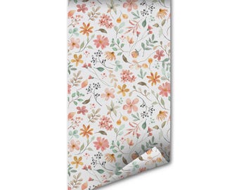 Könnte beinhalten: Eine Tapetenrolle mit einem sich wiederholenden Aquarellmuster aus kleinen Blumen, Blättern und Beeren in zarten Rosa-, gedämpften Orange- und Salbeigrüntönen auf weißem Grund, wobei die untere Ecke aufgerollt ist.