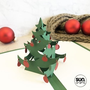 Archivo de trama Tarjeta plegable de árbol de Navidad emergente 3D con bolas que se balancean libremente Tarjeta de Navidad