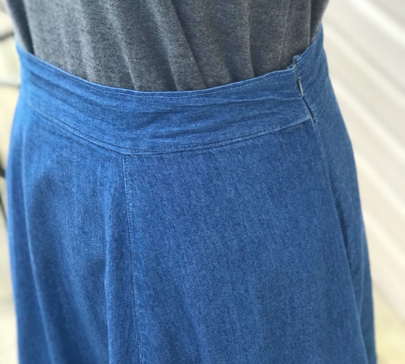May include: A denim skirt with a dark blue wash and a waistband. The skirt is a-line and has a slight flare at the bottom.