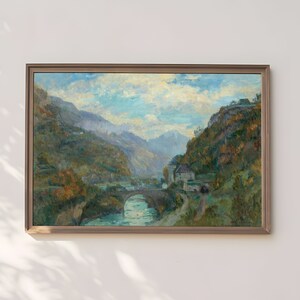 Puede incluir: Pintura al óleo de un paisaje montañoso con un puente de piedra sobre un río. La obra presenta una paleta de colores apagados de verdes, azules y marrones, enmarcada en un marco de madera.