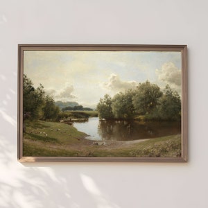 May include: A framed landscape painting depicts a serene river scene. The artwork features a brown river reflecting the sky and surrounding trees. The painting is set in a wooden frame, with a grassy bank and trees on either side of the river.