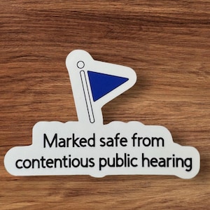 May include: White sticker with a blue flag icon and the text "Marked safe from contentious public hearing".