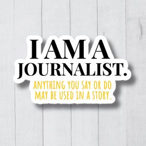 May include: A white sticker with black text that reads "I AM A JOURNALIST. ANYTHING YOU SAY OR DO MAY BE USED IN A STORY."
