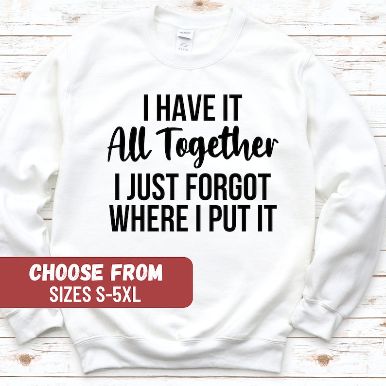Op de afbeelding: Wit sweatshirt met zwarte tekst die "Ik heb het allemaal bij elkaar, ik ben alleen vergeten waar ik het heb neergelegd" luidt. De tekst is in een casual lettertype. Het sweatshirt is verkrijgbaar in de maten S-5XL.