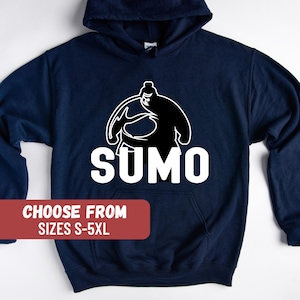 May include: Navy blue hooded sweatshirt with a white graphic of a sumo wrestler and the word "SUMO". The text "CHOOSE FROM SIZES S-5XL" is printed in white on a red rectangle.