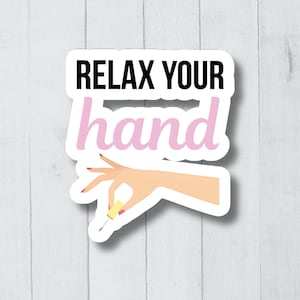 Peut inclure: Un autocollant avec le texte "Relax your hand" en lettres noires et roses. Une main de dessin animé avec des ongles roses tient un flacon de vernis à ongles jaune.