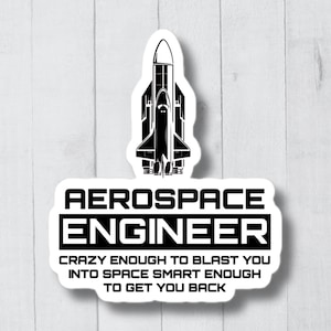 Op de afbeelding: Een witte sticker met een zwart silhouet van een raket en de tekst "AEROSPACE ENGINEER CRAZY ENOUGH TO BLAST YOU INTO SPACE SMART ENOUGH TO GET YOU BACK".