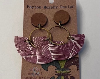 May include: A pair of handmade earrings with a purple and white patterned design, gold hoops, and brown wooden tops. The earrings are displayed on a card that reads "Payton Murphy Design, unique & unusual handmade jewelry".