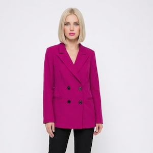 Puede incluir: Un blazer magenta de doble botonadura con botones negros, combinado con pantalones negros y tacones negros. El blazer tiene una solapa clásica y un corte entallado, creando un look profesional y elegante. Adecuado para negocios u ocasiones formales.