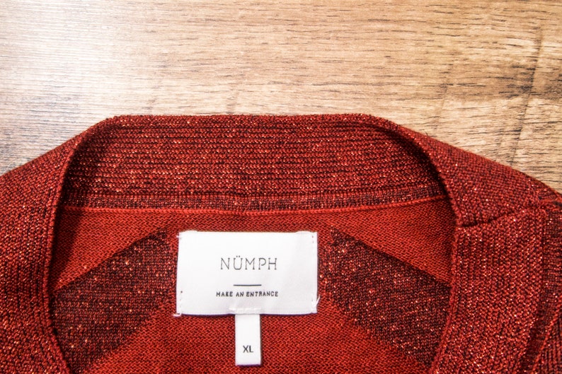 May include: Red sparkly sweater with a white tag that says "N&Uuml;MPH" and "MAKE AN ENTRANCE" with a size XL label.