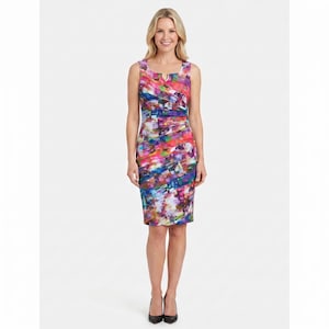 Könnte beinhalten: Ein ärmelloses, knielanges Kleid mit einem lebendigen, abstrakten Druck in Rosa-, Blau-, Lila- und Grüntönen. Das Kleid hat einen U-Ausschnitt und ein gerafftes Taillendetail. Das Model trägt schwarze Absätze.