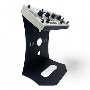 May include: A black metal stand with a white electronic device on top. The device has several knobs and buttons and the text "ARCADE" on the front.