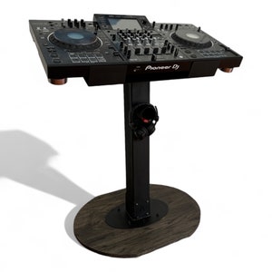 May include: Black DJ mixer on a black stand with a wooden base. The mixer has two large knobs and a screen. The stand has a headphone holder. The text "Pioneer DJ" is visible on the mixer.