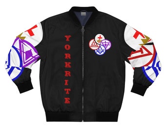 Puede incluir: Chaqueta bomber negra con una inscripción "YORKRITE" roja en el lado izquierdo. La manga derecha presenta un diseño colorido de símbolos masónicos, incluyendo un compás y una escuadra, una cruz y una corona.