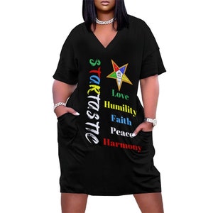 Peut inclure: Robe t-shirt noire à manches courtes avec une étoile à cinq branches et les mots "starcastic" et "Love, Humility, Faith, Peace, Harmony" imprimés sur le devant.