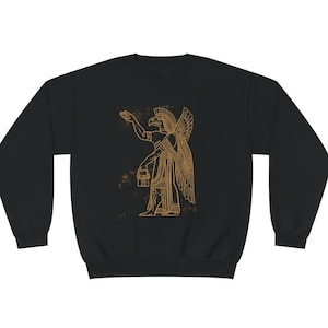 May include: Black sweatshirt featuring a gold outline of a winged human figure with a bird's head holding a bucket.