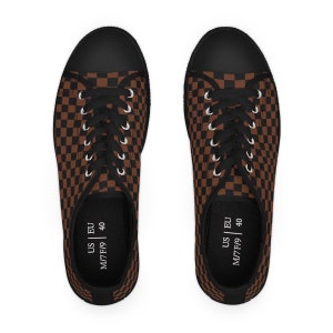 May include: A pair of black canvas shoes with brown and black checkered pattern. The shoes have black laces and white text on the inside that reads "US | EU M/7F/9 40".