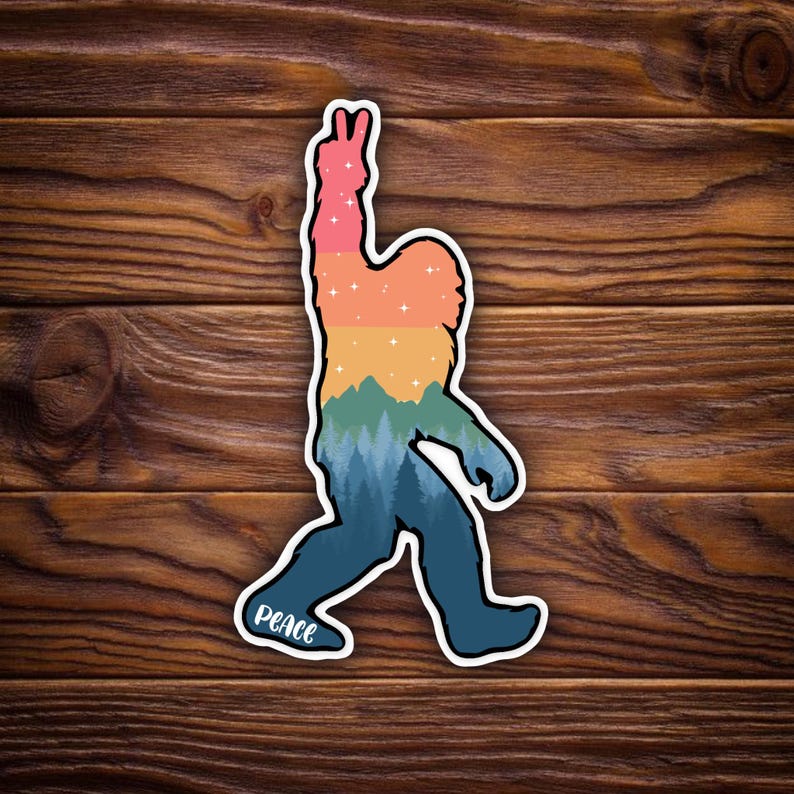 May include: A sticker featuring a colorful Bigfoot silhouette with a peace sign. The design includes a gradient of colors, including pink, orange, yellow, green, and blue, with a forest scene at the bottom. The word "PEACE" is written on the bottom.