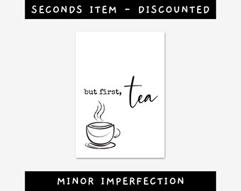 May include: White print with the text "but first, tea" above a line drawing of a teacup with steam. The image is a seconds item with a minor imperfection.